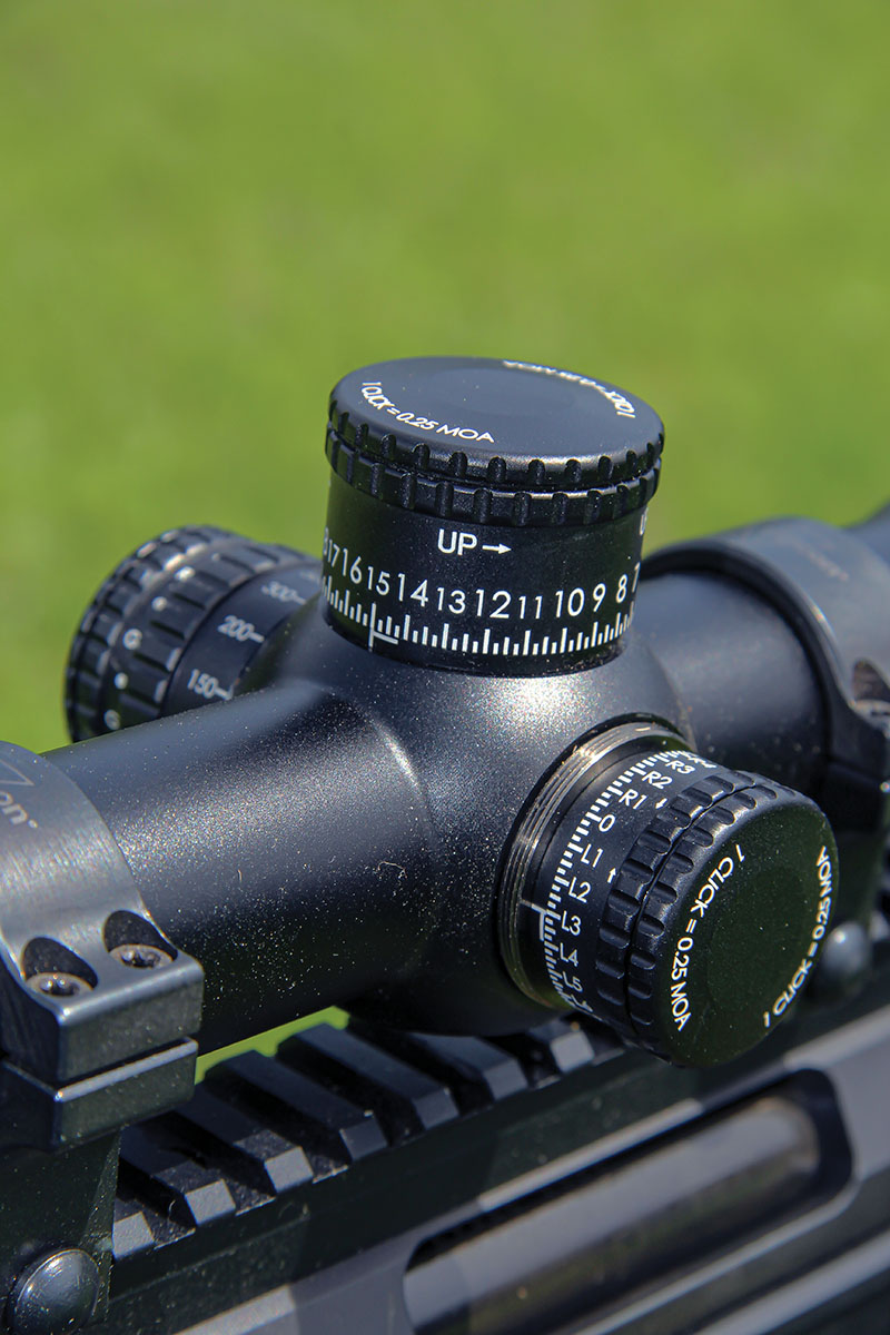 The elevation turret of the Trijicon Tenmile HX is exposed, while the windage turret includes a threaded aluminum cover cap. The scope includes 50-MOA of elevation and 40-MOA of windage movements.